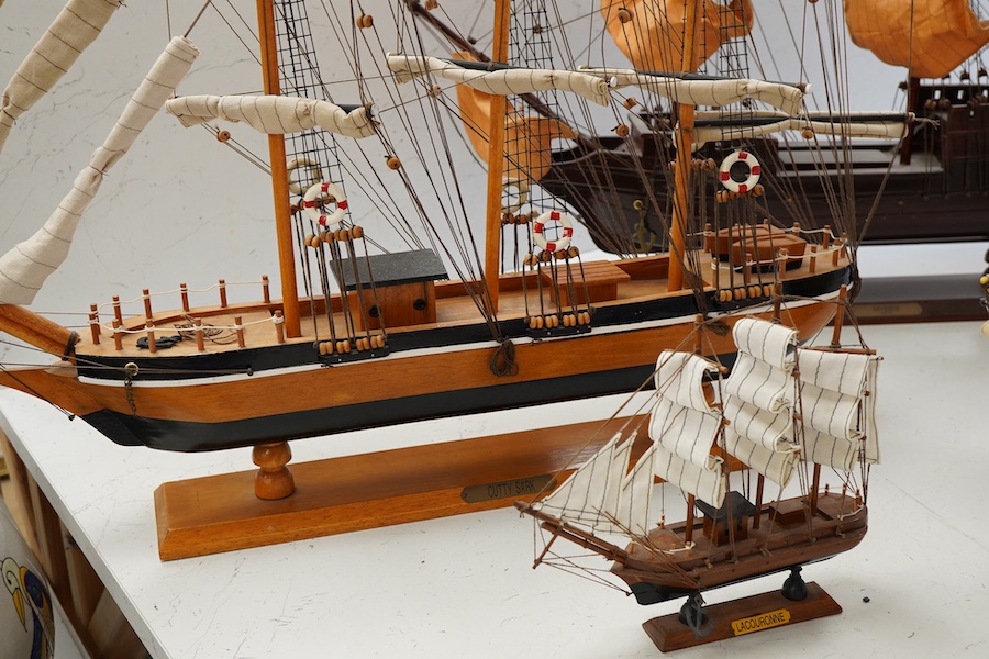 A collection of ten wooden models of famous ships including; the Cutty Sark, HMS Victory, the Mayflower, Revenge, and Santa Maria, largest 125cm wide